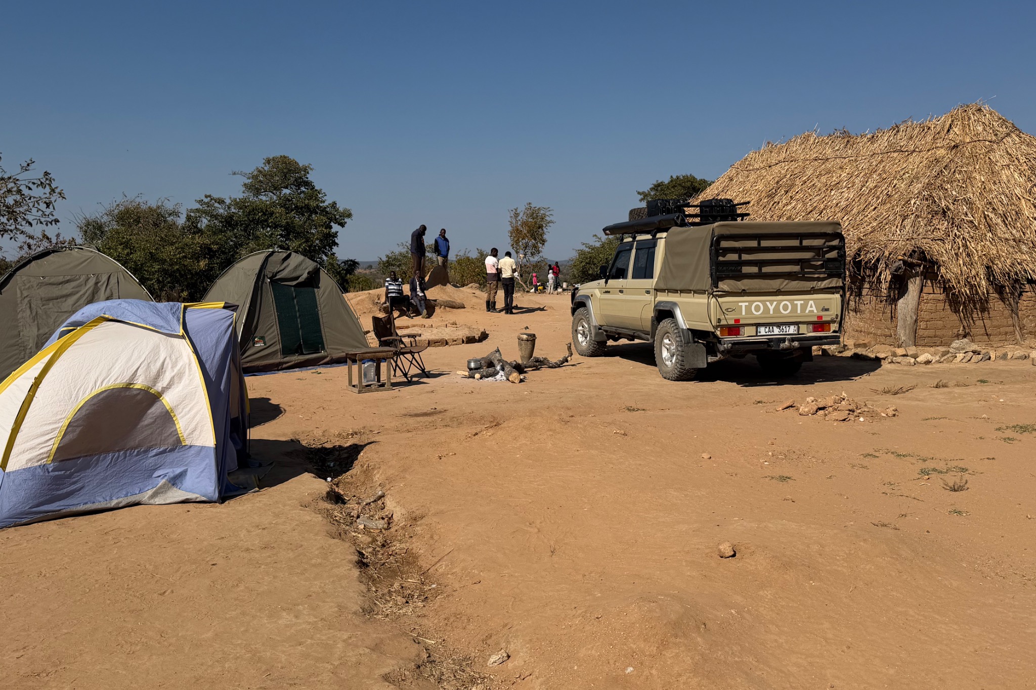 Original CGWU campsite photograph showing tents, a Toyota Land Cruiser and a rural Zambian village